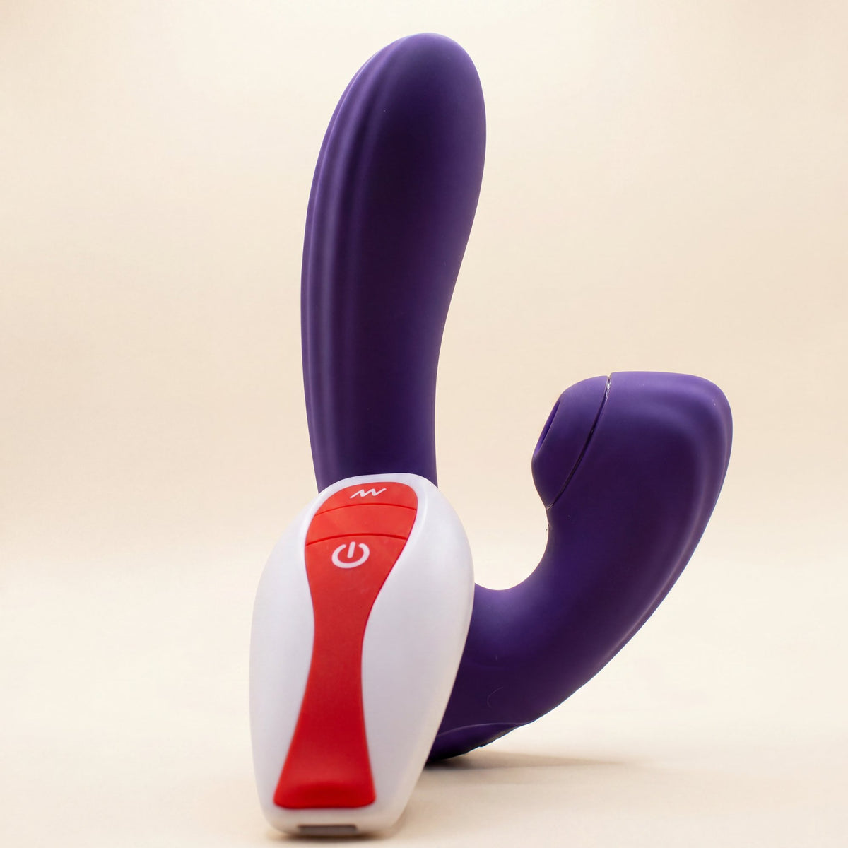 Sucking Sweet in purple silicone with its white and red remote on a cream ground