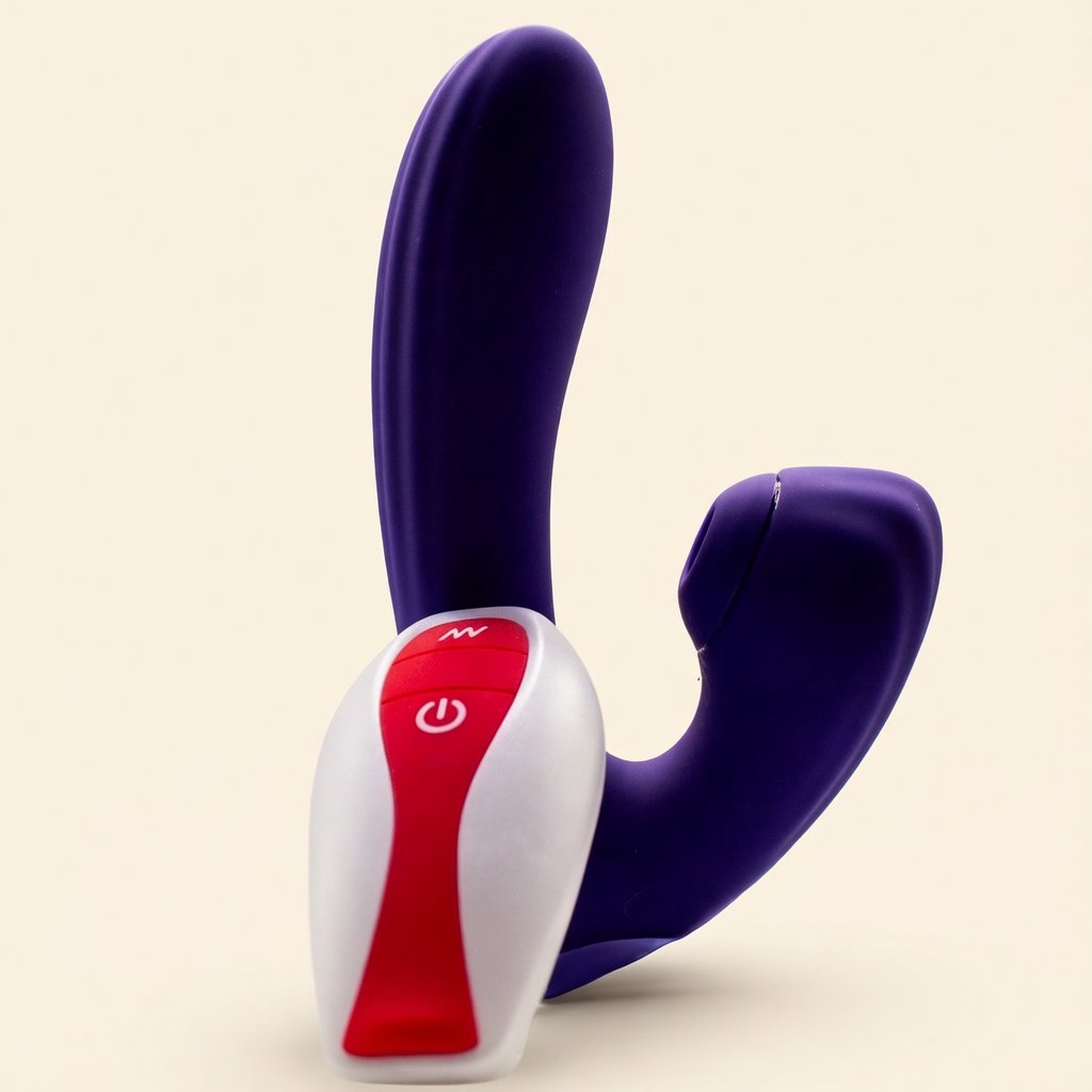 Sucking Sweet in deep purple silicone with its white and red remote in front, on a cream ground